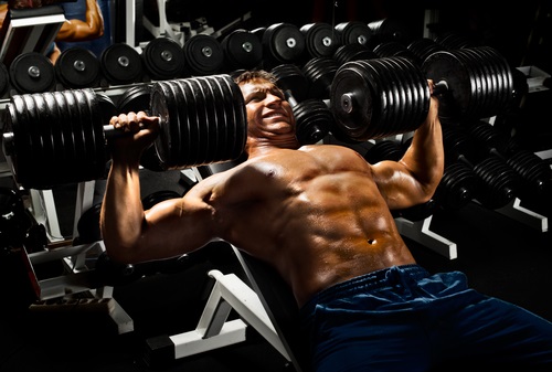 Man Pressing Heavy Dumbbells had better change his training methods to high repetition training soon